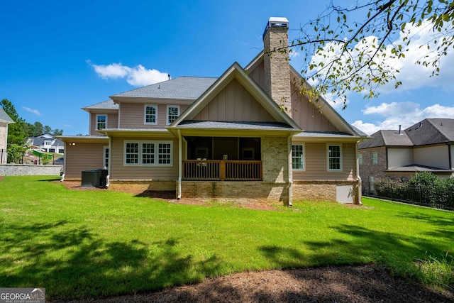 rear view of house with a yard and cooling unit