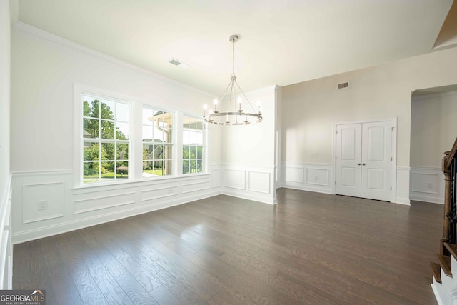 unfurnished dining area with a chandelier, crown molding, and dark wood-type flooring