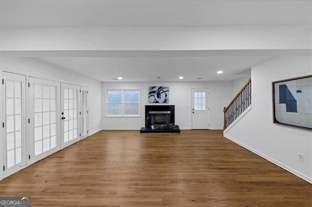 unfurnished living room featuring hardwood / wood-style flooring and french doors