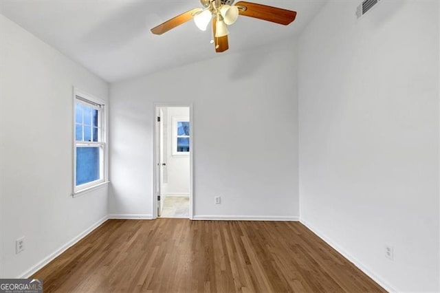 spare room with wood-type flooring, ceiling fan, and vaulted ceiling