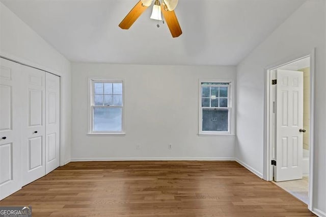 unfurnished bedroom featuring lofted ceiling, hardwood / wood-style floors, and ceiling fan