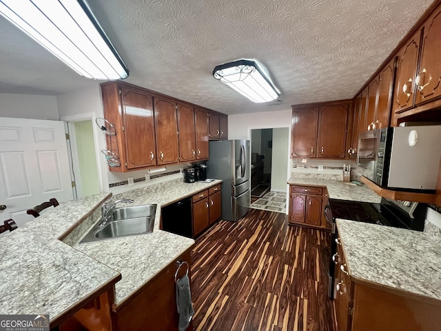 kitchen with sink, a breakfast bar area, a textured ceiling, dark hardwood / wood-style flooring, and stainless steel appliances