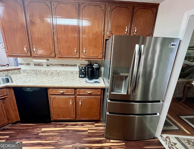 kitchen with stainless steel refrigerator with ice dispenser, black dishwasher, dark wood-type flooring, and sink