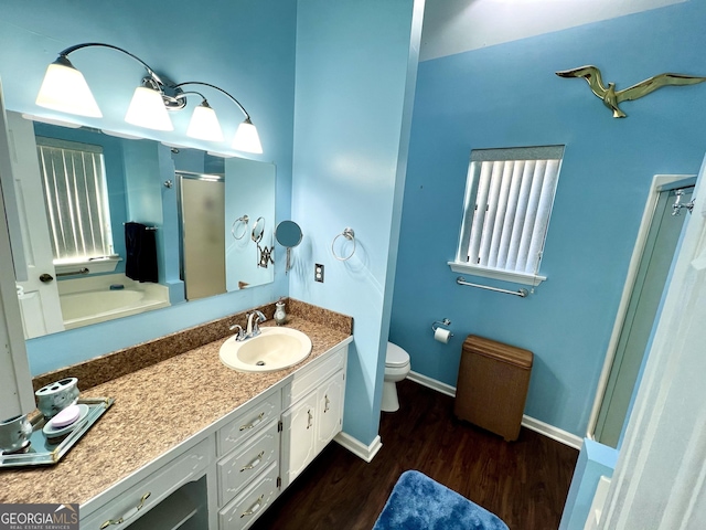 bathroom featuring toilet, vanity, an enclosed shower, and hardwood / wood-style flooring