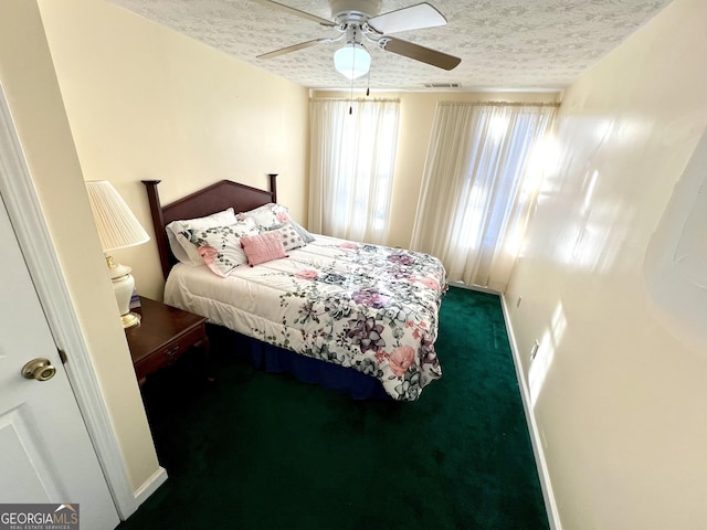 carpeted bedroom featuring ceiling fan and a textured ceiling