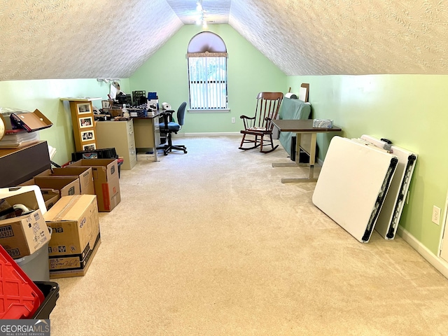 office with a textured ceiling, light colored carpet, and lofted ceiling