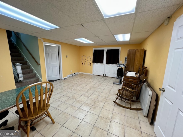 living area featuring light tile patterned floors and a paneled ceiling