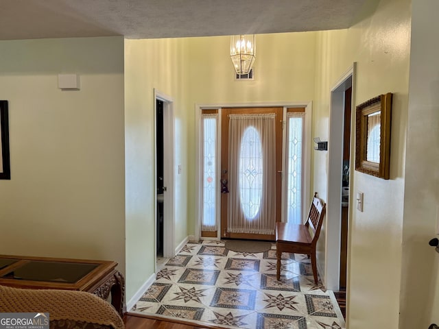 foyer with light hardwood / wood-style flooring and a notable chandelier