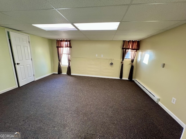 unfurnished room featuring baseboard heating, carpet flooring, plenty of natural light, and a drop ceiling