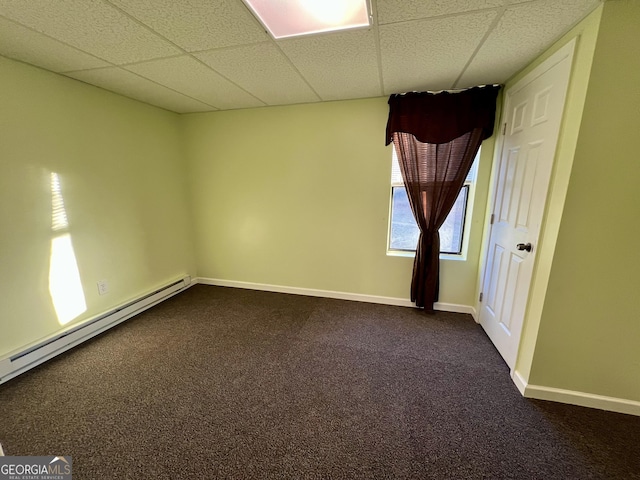 carpeted spare room with a paneled ceiling and baseboard heating