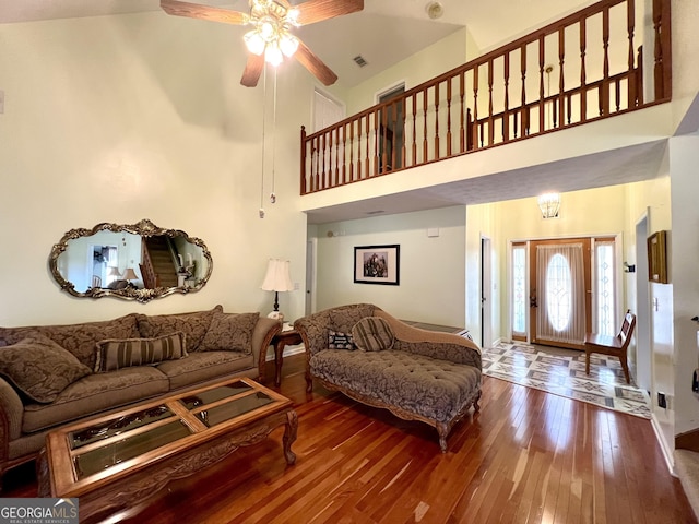 living room with ceiling fan, high vaulted ceiling, and wood-type flooring