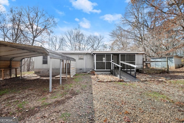 back of property featuring a carport and a sunroom