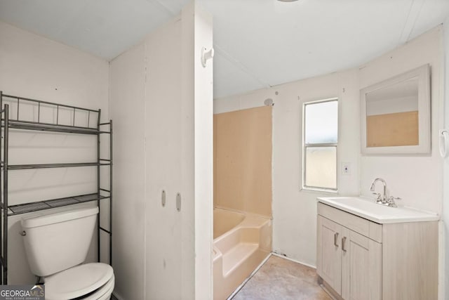 bathroom with a washtub, vanity, and toilet