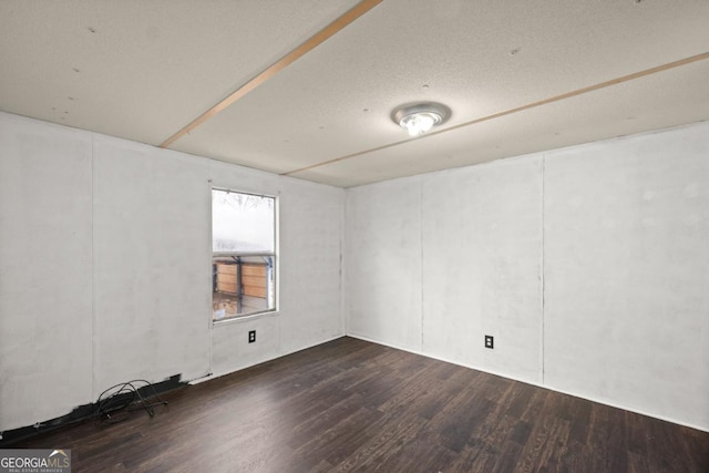 spare room featuring dark wood-type flooring