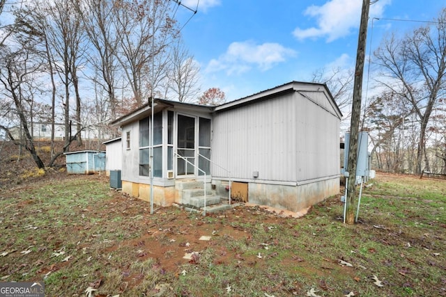 view of side of home featuring central AC and a sunroom