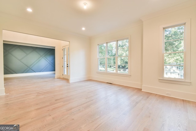 unfurnished living room with ornamental molding, a healthy amount of sunlight, and light hardwood / wood-style flooring