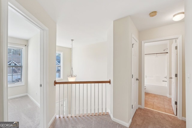 hallway featuring light colored carpet