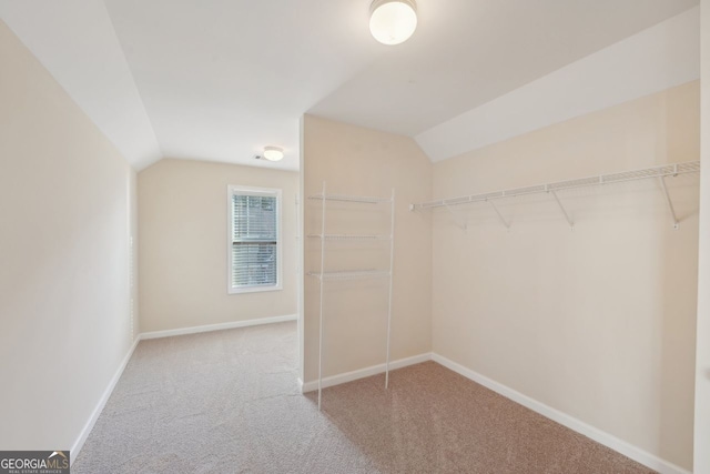 walk in closet featuring carpet floors and vaulted ceiling