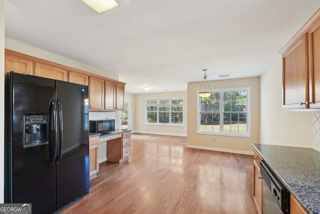 kitchen featuring backsplash, black appliances, hanging light fixtures, built in desk, and light hardwood / wood-style floors