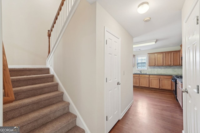 stairway featuring hardwood / wood-style flooring and sink