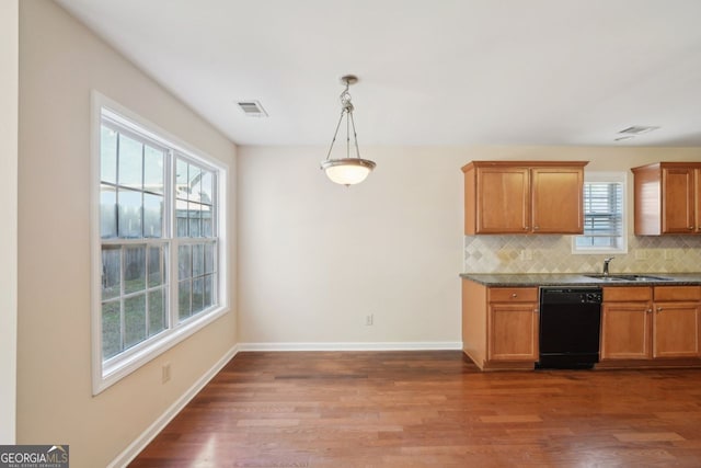 kitchen with backsplash, sink, decorative light fixtures, black dishwasher, and dark hardwood / wood-style floors