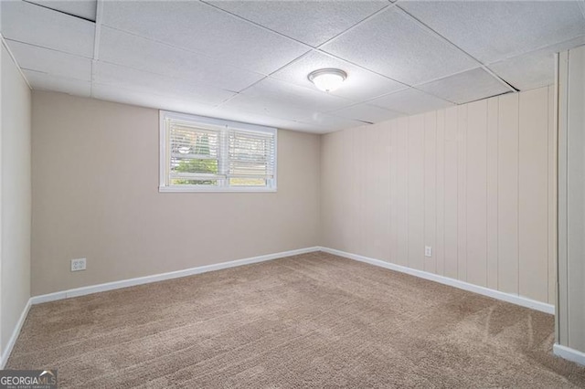 carpeted empty room with a drop ceiling