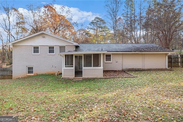 back of property with a yard and a sunroom