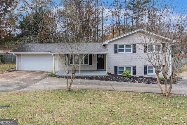 split level home with covered porch, a garage, and a front yard