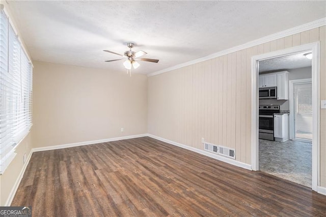 unfurnished room with a textured ceiling, crown molding, ceiling fan, and dark wood-type flooring