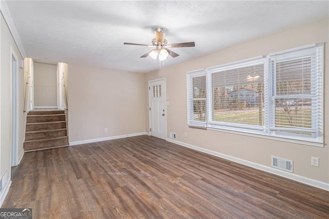 unfurnished room featuring ceiling fan, dark hardwood / wood-style flooring, and a textured ceiling