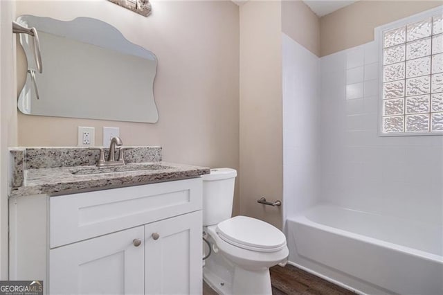 full bathroom with shower / tub combination, vanity, hardwood / wood-style flooring, and toilet