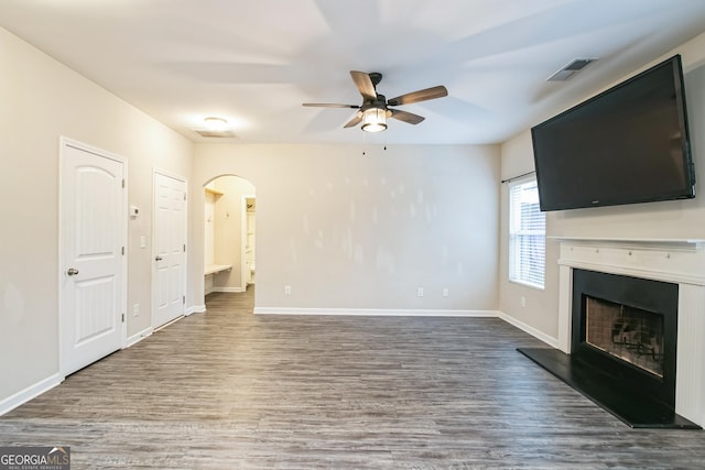 unfurnished living room featuring dark hardwood / wood-style flooring and ceiling fan