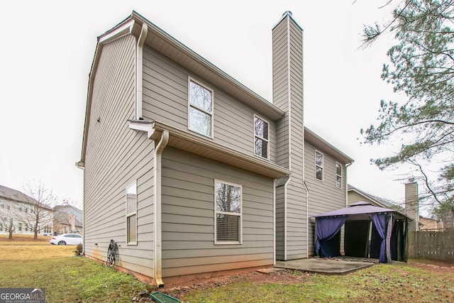 rear view of property featuring a lawn and a patio area