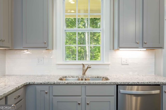 kitchen featuring dishwasher, gray cabinets, light stone counters, and sink