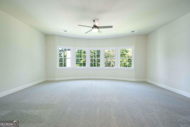 carpeted spare room with ceiling fan and plenty of natural light