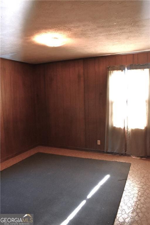 unfurnished room with wood walls