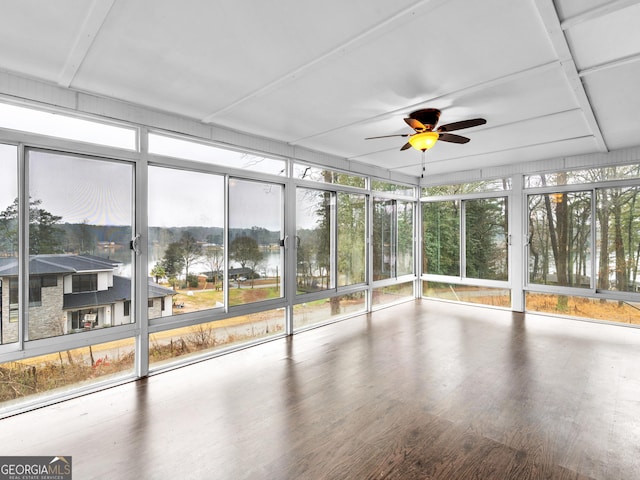 unfurnished sunroom featuring a water view and ceiling fan