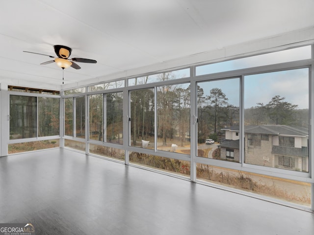 unfurnished sunroom featuring ceiling fan and a wealth of natural light