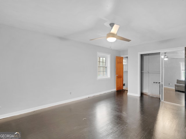 unfurnished bedroom with dark hardwood / wood-style flooring, a closet, and ceiling fan