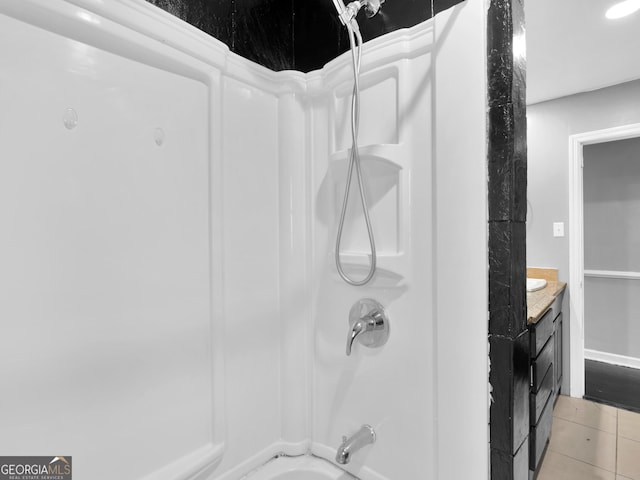 bathroom featuring tile patterned flooring, vanity, and bathing tub / shower combination