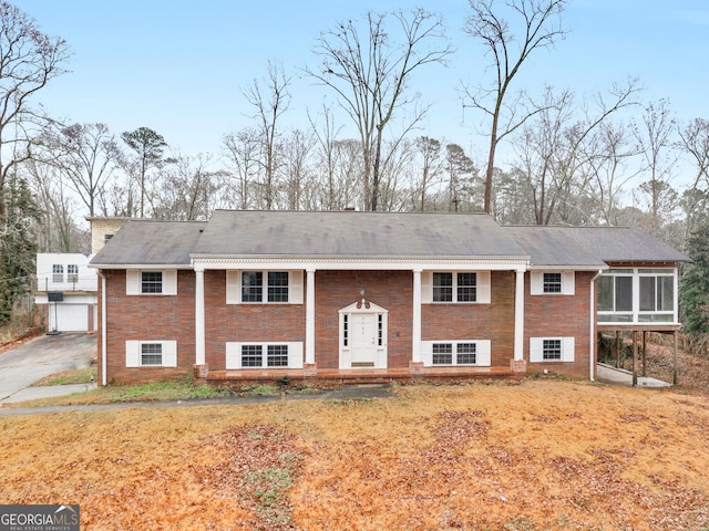 split foyer home featuring a sunroom and a front yard