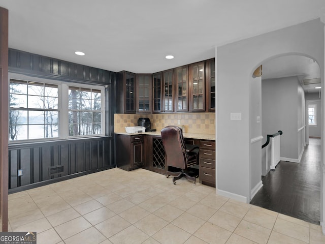 office area with light wood-type flooring, built in desk, and a wealth of natural light