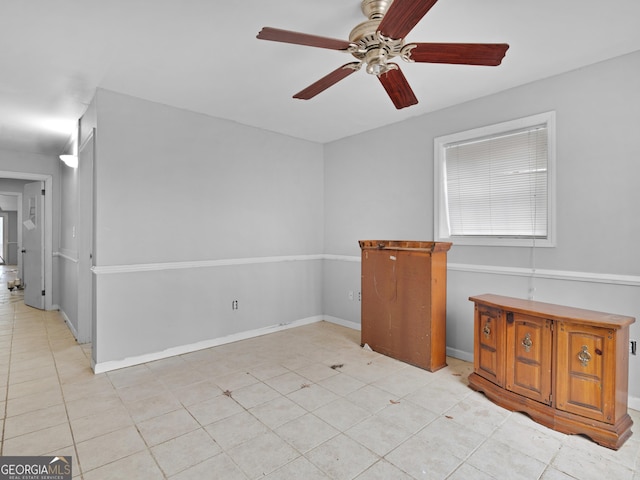 tiled spare room with ceiling fan