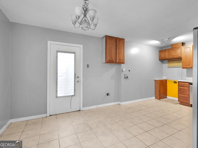 laundry area featuring cabinets, hookup for an electric dryer, hookup for a washing machine, a chandelier, and light tile patterned flooring