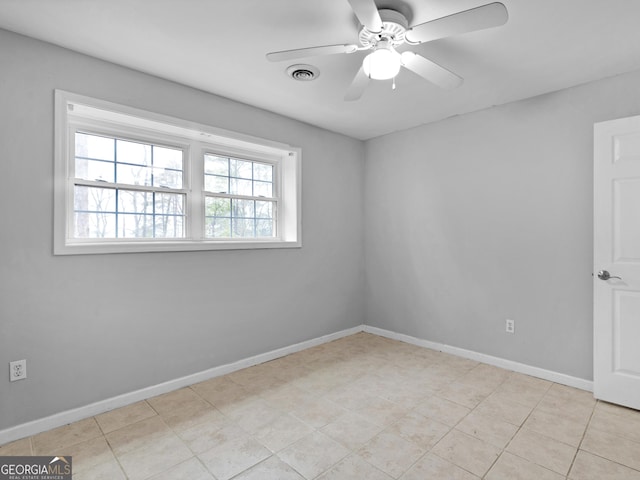 tiled spare room with ceiling fan