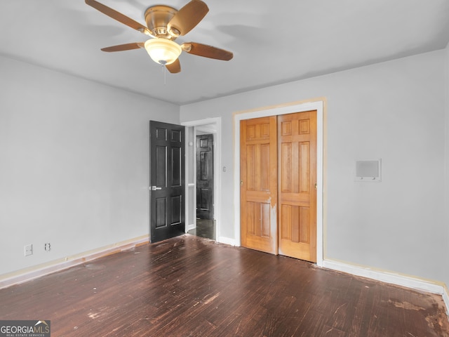 unfurnished bedroom featuring ceiling fan, a closet, and wood-type flooring