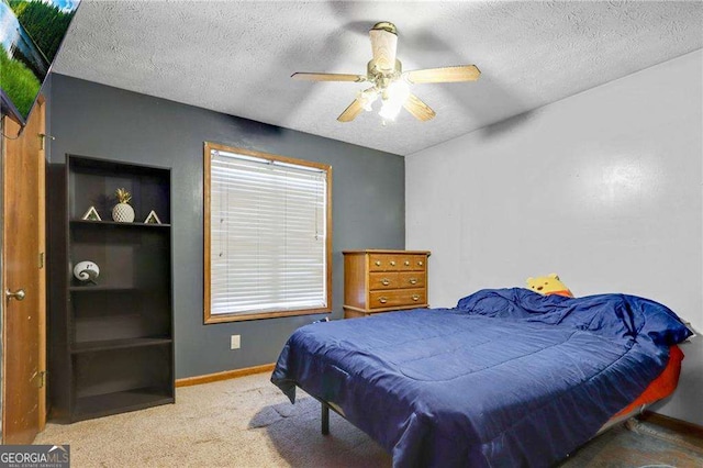 bedroom featuring ceiling fan, carpet floors, and a textured ceiling