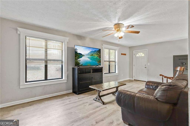 living room with a textured ceiling and light hardwood / wood-style floors