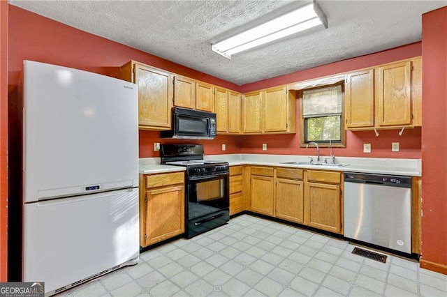 kitchen featuring sink, black appliances, and a textured ceiling