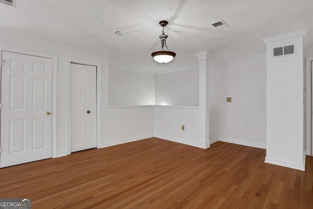 spare room with wood-type flooring and ornamental molding